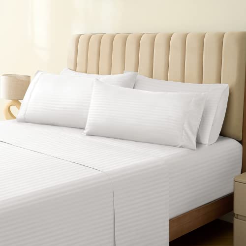 a bed with white sheets and pillows